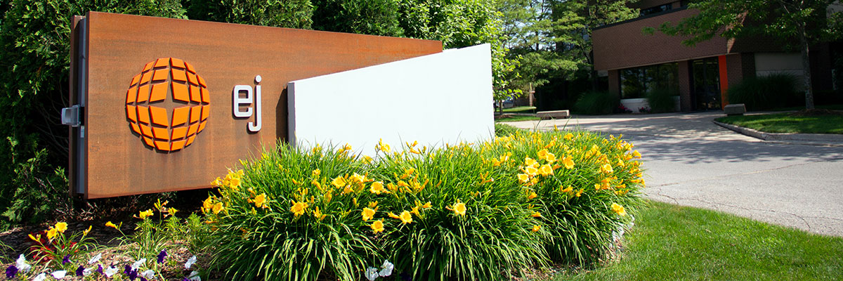 EJ Corporate Office company sign with flowers in front of building
