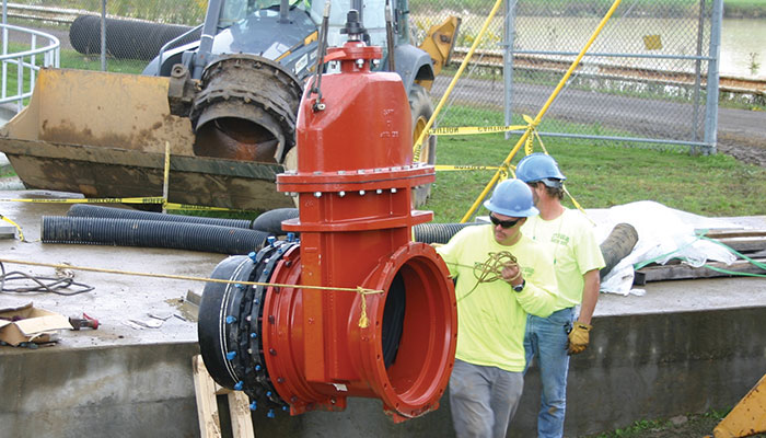 EJ FlowMaster resilient wedge gate valve being lifted by workers