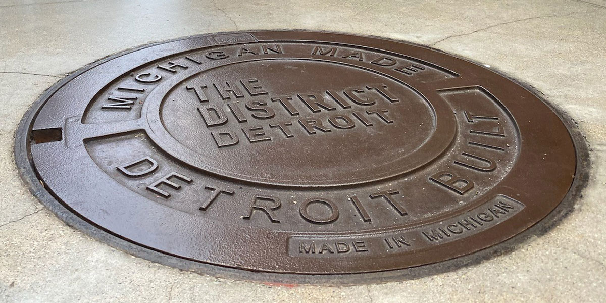 EJ DETROIT cast iron custom logo cover in sidewalk